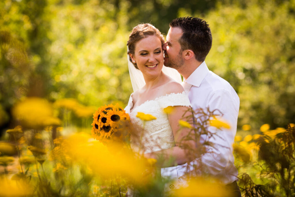Bijzondere trouwfoto's - bruidspaar tussen de zonnebloemen