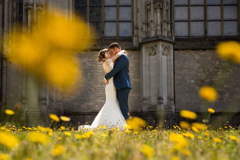 Trouwfotograaf Den Bosch - bruidspaar tussen de bloemen voor de Sint Jans kathedraal in Den Bosch