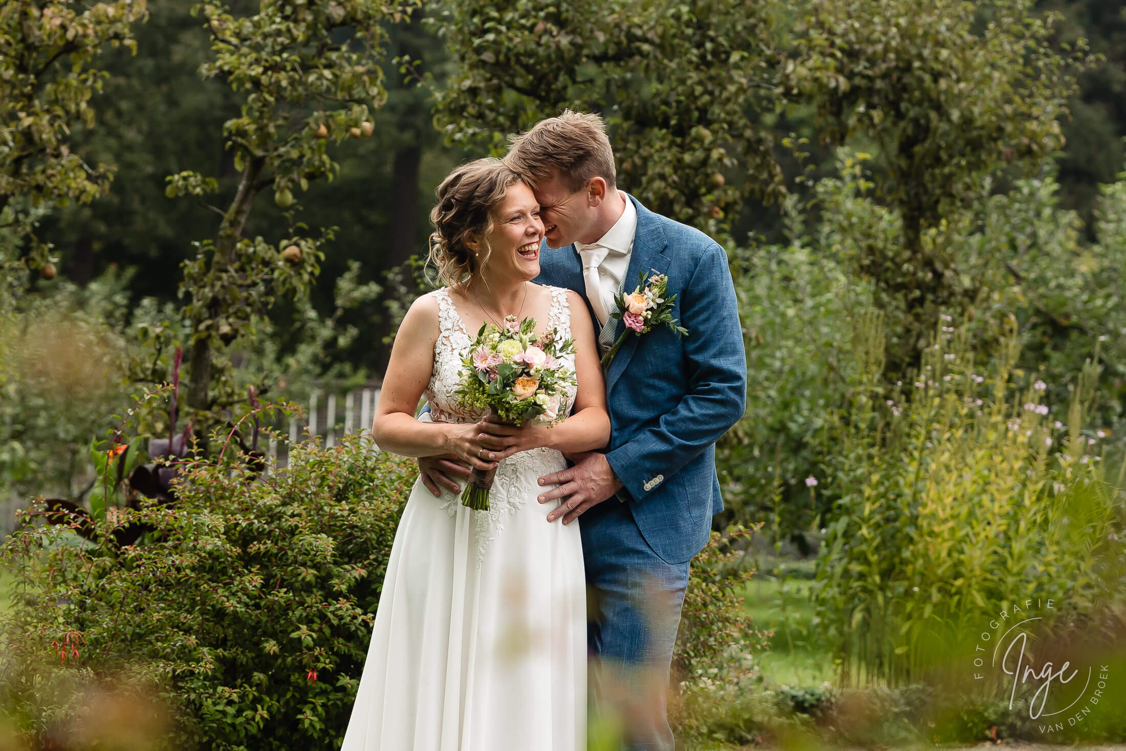 Bruidspaar tijdens fotoreportage met corsage bij de bruidegom en bruid met trouwboeket