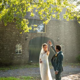 Bruidsfotografie - bruidspaar danst in prachtige zonnestralen